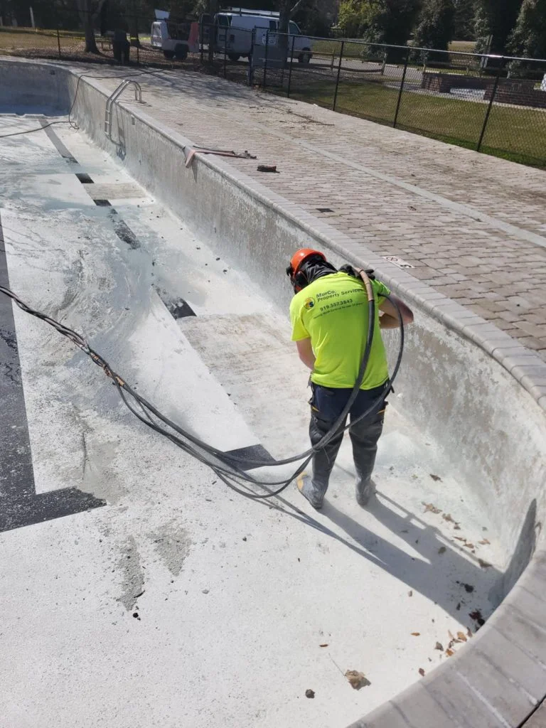 hydroblasting technique being used on the interior of a pool